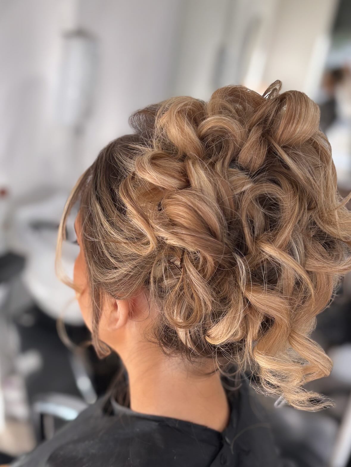 Curled blonde bridal updo at The Dollz House