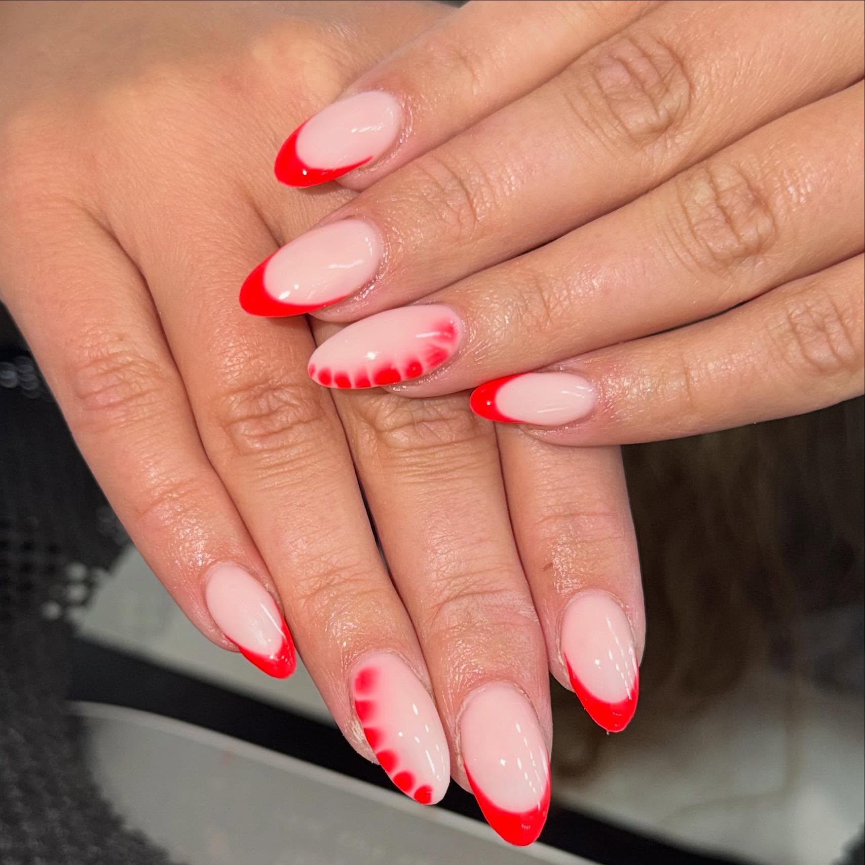 Almond gel nails with red French tips and heart art